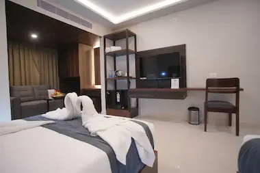 Club Room amenities at BLOFT HOTEL, Vellore including minibar, TV unit, kettle, and cozy lounge with welcome fruit platter