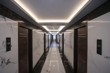 Elegant hotel corridor with ambient lighting and marble flooring at Bloft Hotel Vellore.