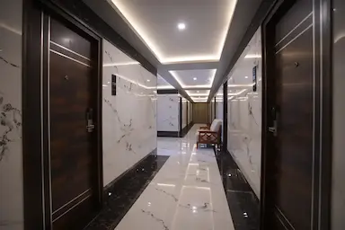 Corridor with marble design and soft lighting at Bloft Hotel Vellore.