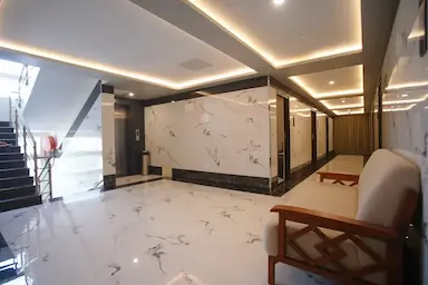 Modern and well-lit corridor with marble flooring and elevator access at Bloft Hotel, Vellore.