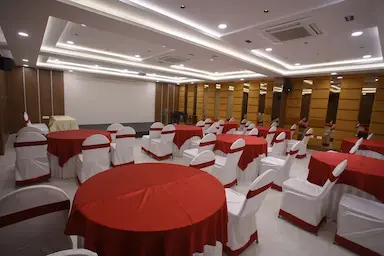 Banquet hall arranged with red and white tablecloths for an event at Bloft Hotel Vellore.